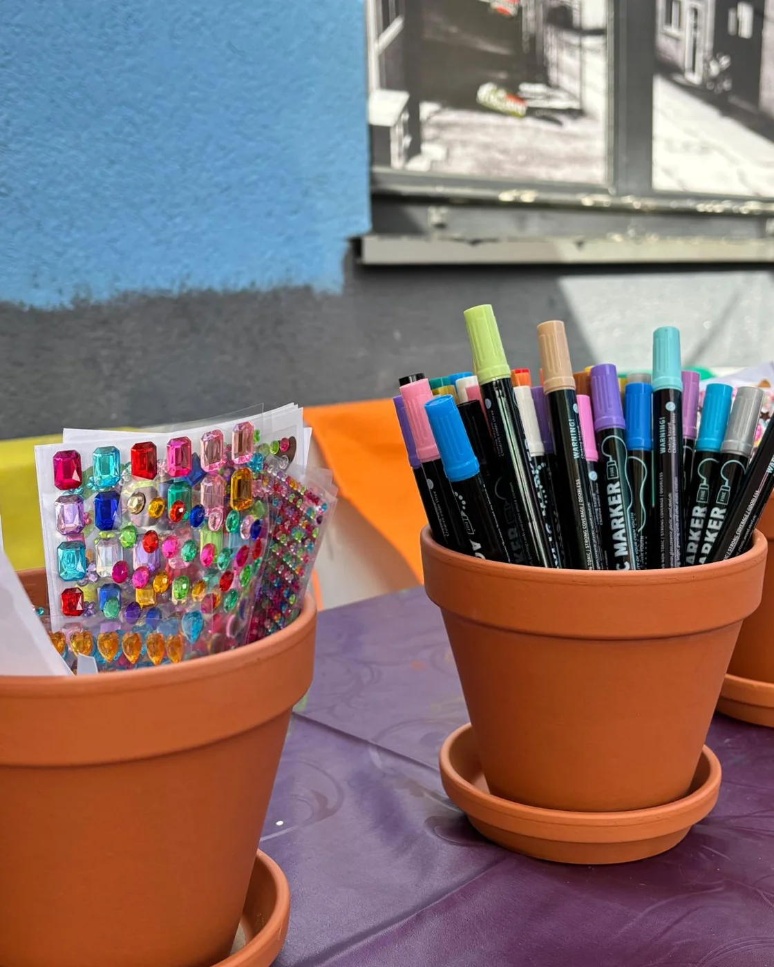Pots en terre cuite, feutres et strass prêts pour un atelier Keskonbricole